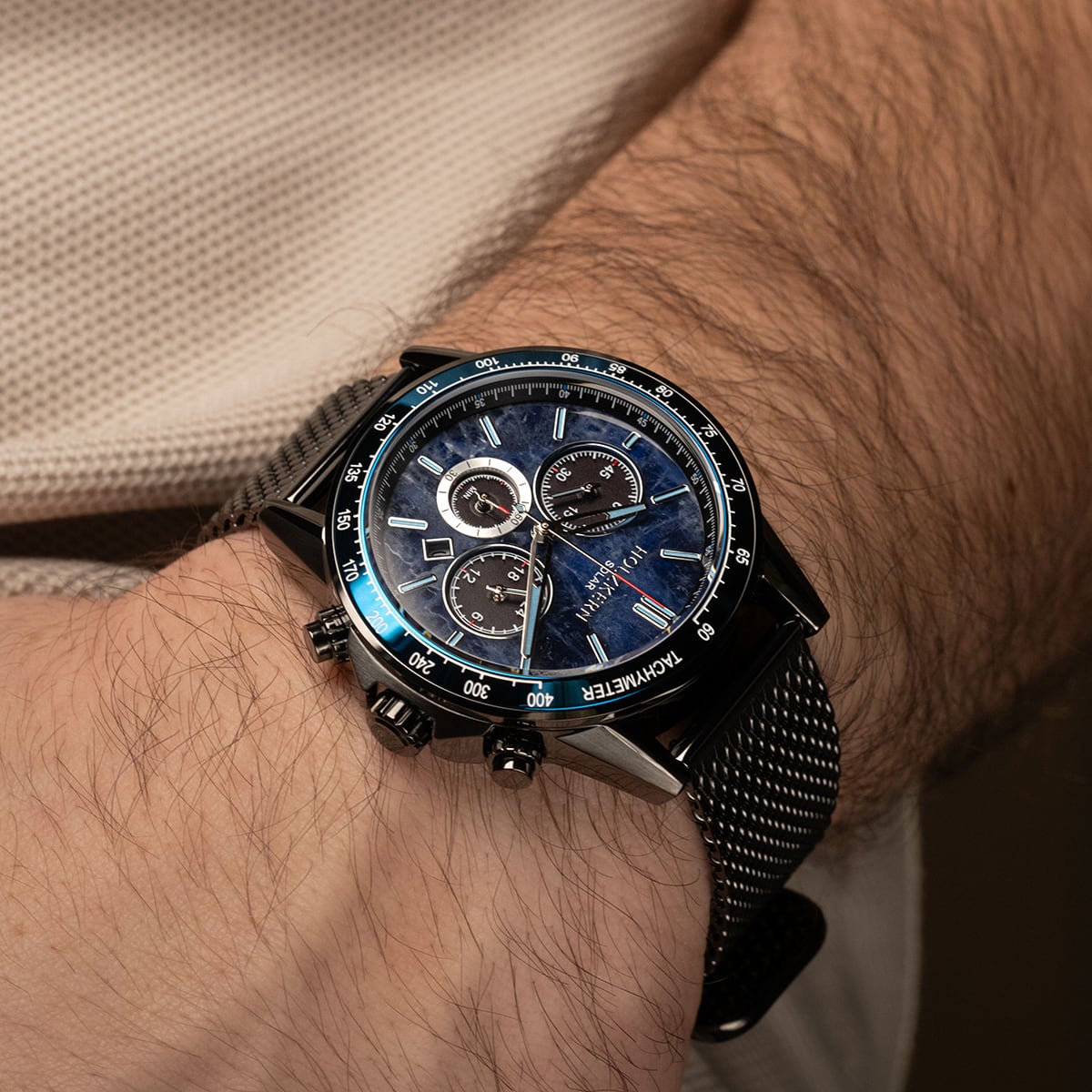 "Comfort Crusher", a stylish watch with sodalite blue and dark gray accents, on wrist display.
