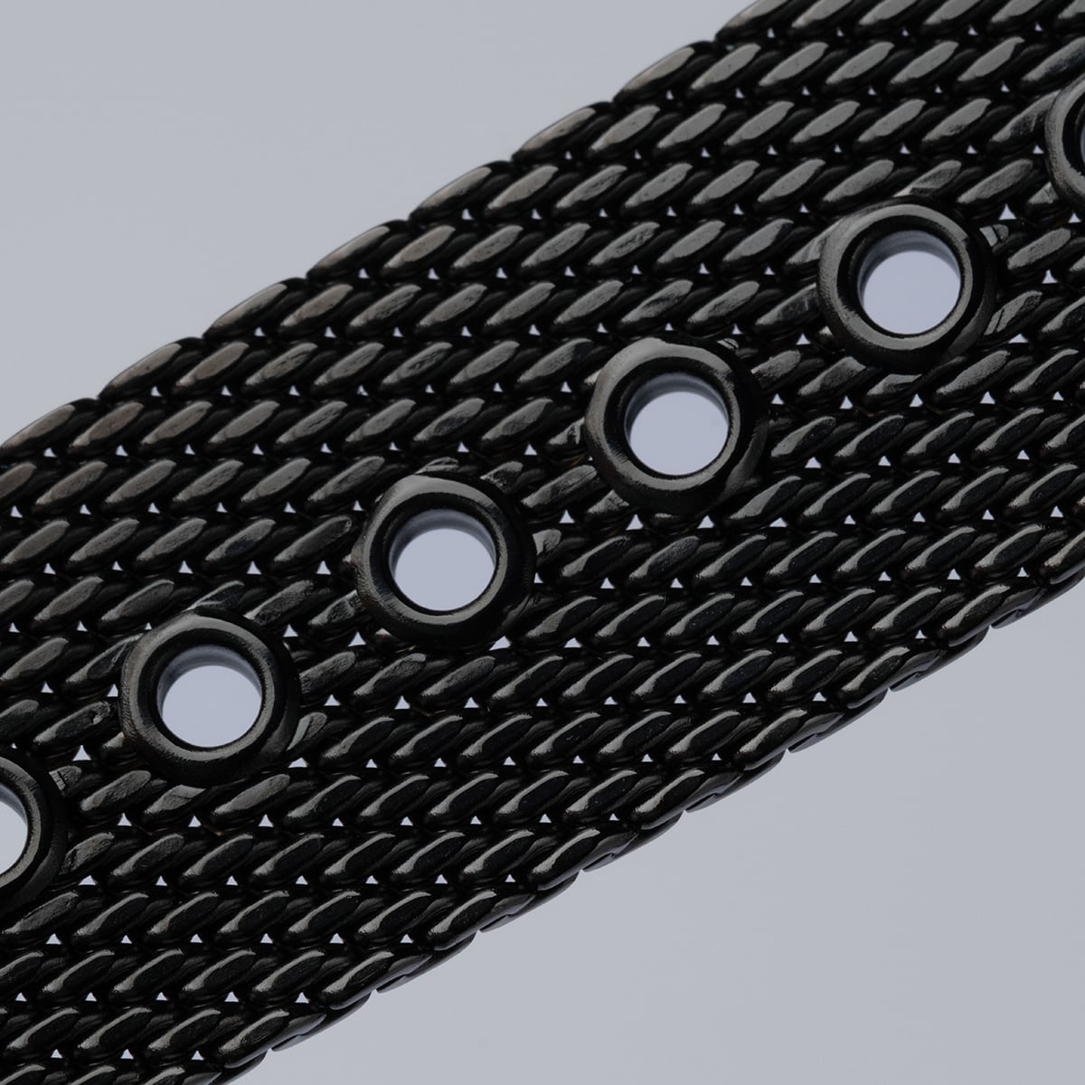 "Comfort Crusher", belt with textured dark gray and sodalite design featuring circular cutouts.