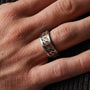 "Baritone Rings" ring in Walnut and Silver, featuring a geometric design on a hand.