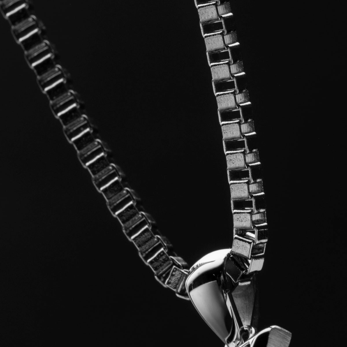 "Baritone Necklaces", a stylish necklace, featuring a sleek walnut and silver design against a black background.