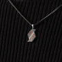 "Baritone Necklaces" necklace featuring a modern pendant design in Walnut and silver on a textured black background.