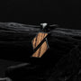 "Baritone Necklaces" necklace with geometric design in zebrawood and black finish, against a dark, textured background.
