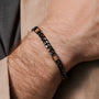 "Bodyguards Strap" bracelet with walnut and dark gray elements, featuring a sleek, modern design.