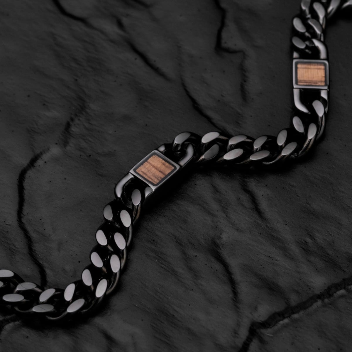 "Bodyguards Strap" strap featuring walnut accents and a dark gray style, laid on a textured black surface.