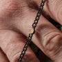 "Bodyguards Necklaces" necklace featuring a dark gray chain and Tiger's Eye accent, showcasing a sleek, modern design.