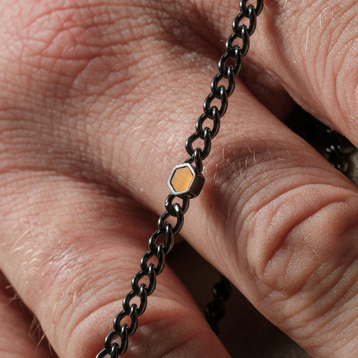 "Bodyguards Necklaces" necklace featuring a dark gray chain and Tiger's Eye accent, showcasing a sleek, modern design.