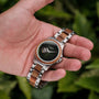 "Whisperwood" watch with a classic blend of koa wood and leaf design, featuring a stainless steel bracelet.
