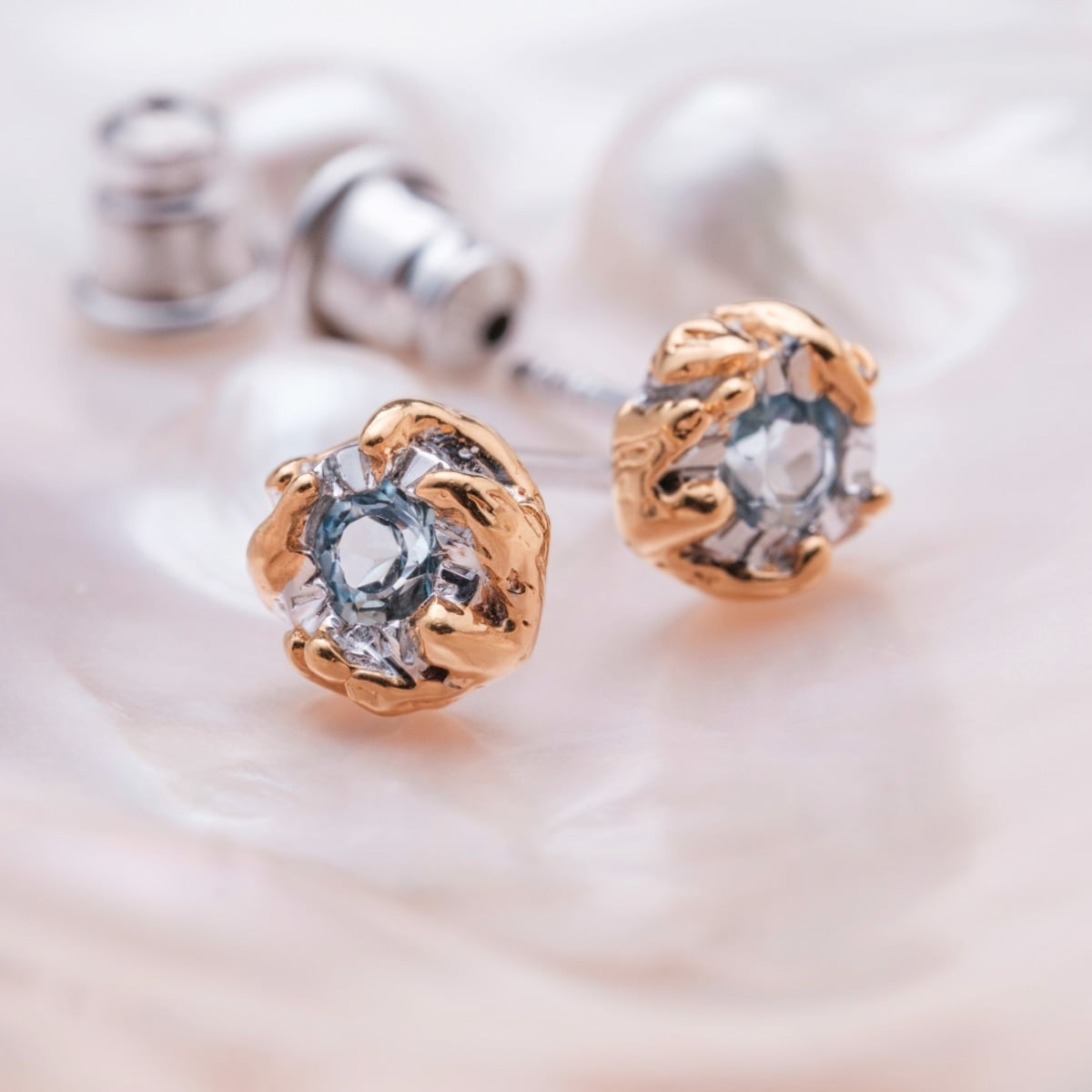 "Silverstream Earrings", elegant earrings featuring topaz and gold accents against a soft background.