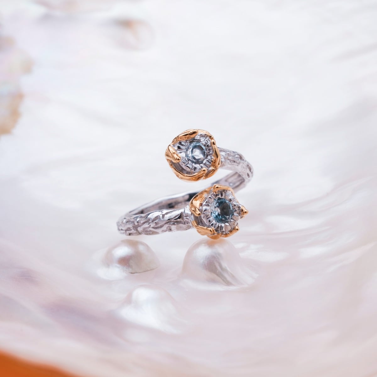 Silverstream Ring featuring a twisted design in silver and gold with topaz stones, exuding elegance and sophistication.