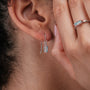 "Silverstream Earrings earrings, featuring aquamarine stones and rosegold accents, displayed on an ear for elegant style."