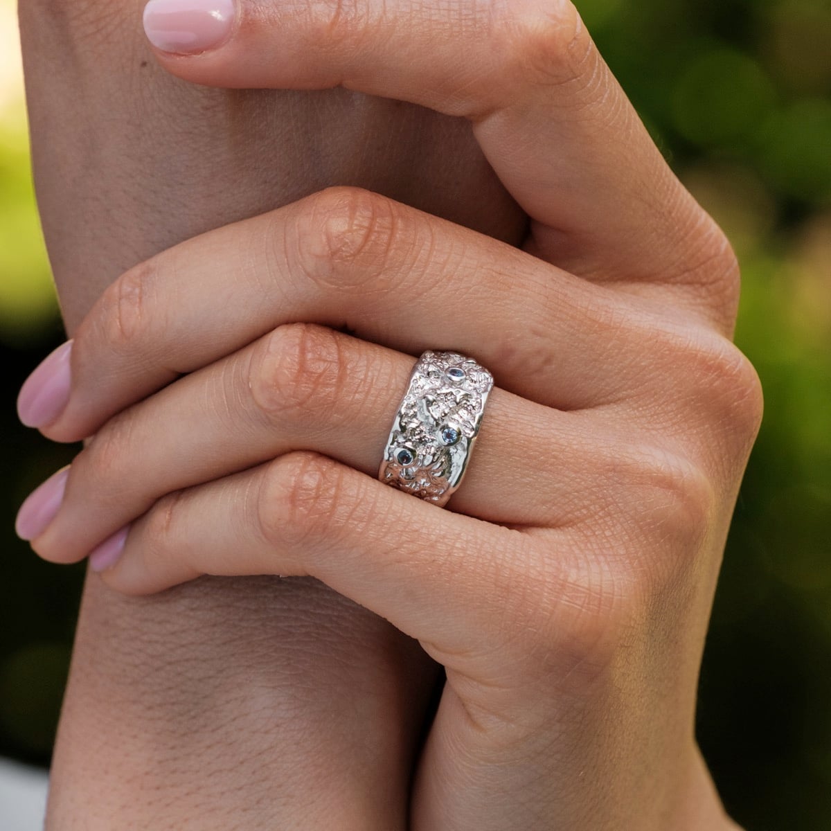 "Silverstream Ring", a silver ring with topaz accents, featuring a textured, artisanal design.