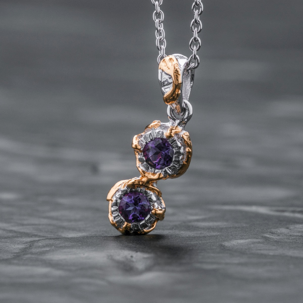 "Silverstream Necklace" necklace featuring amethyst gemstones with gold accents and a sleek, elegant design.