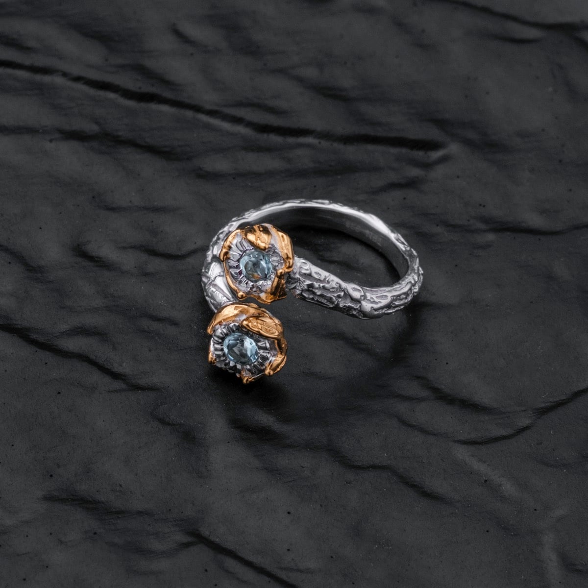 "Silverstream Ring" ring featuring topaz and gold accents with a textured, elegant design.