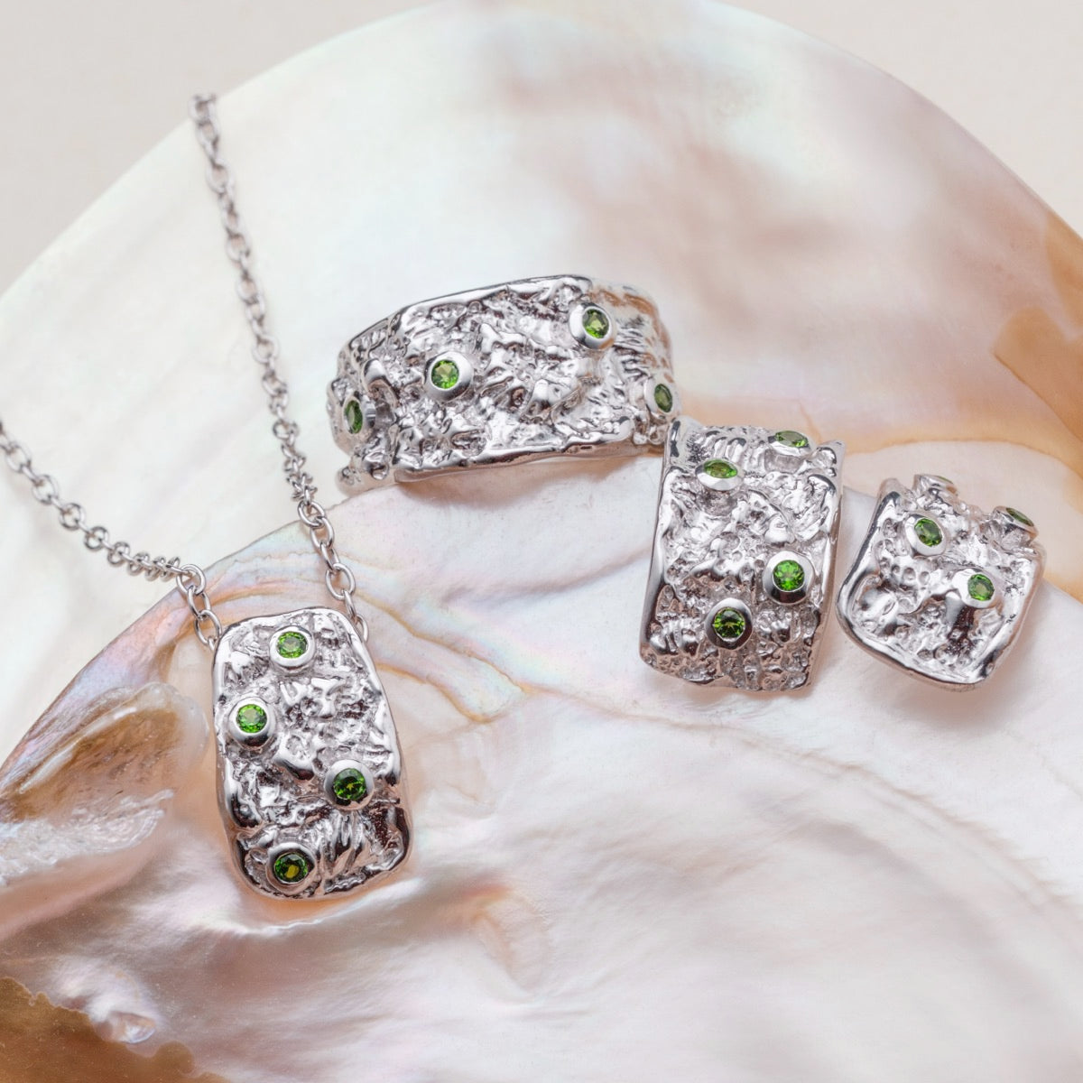 Silverstream earrings, featuring silver with diopside accents, showcasing a textured and elegant design.