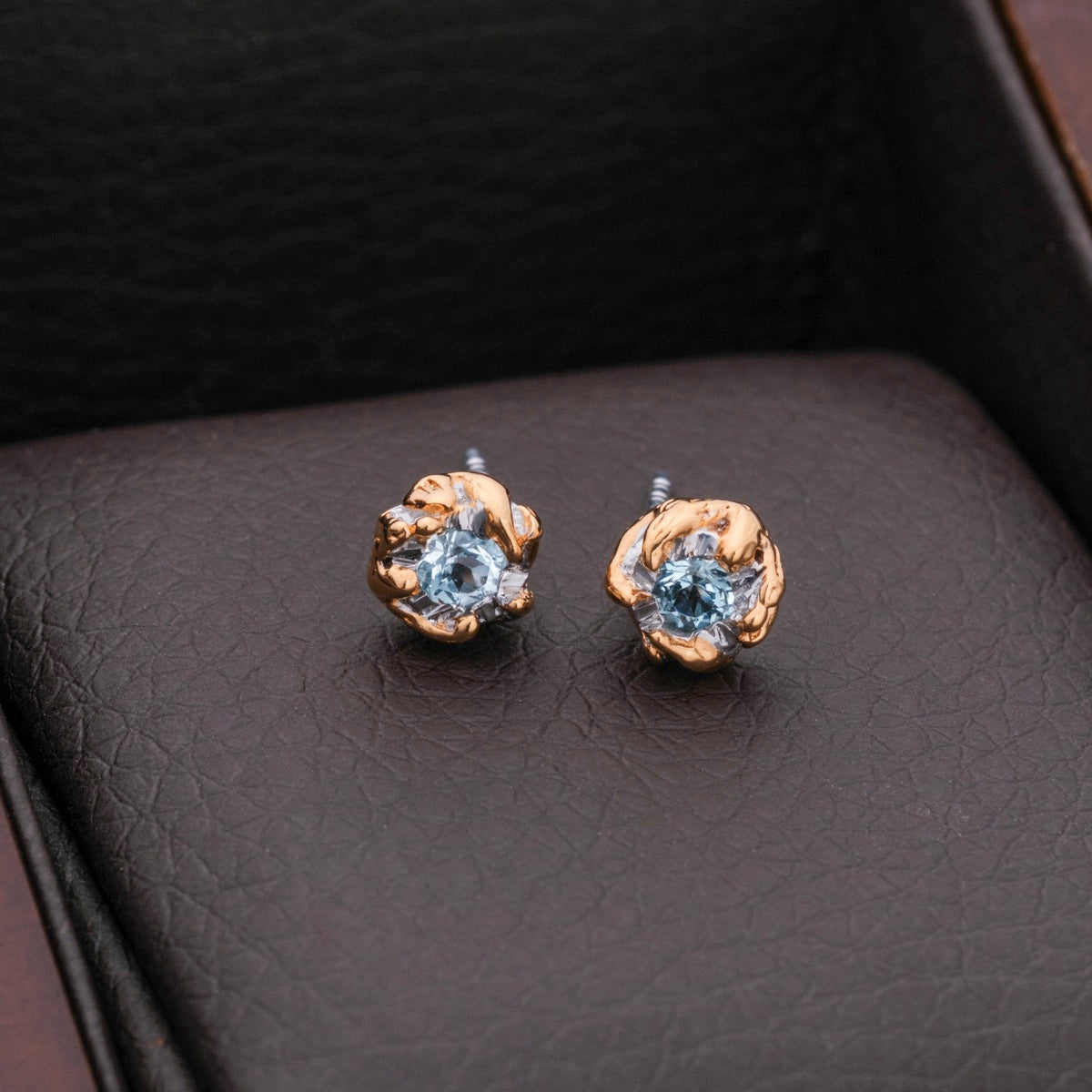Silverstream Earrings: Elegant earrings featuring topaz set in gold, with a floral design.