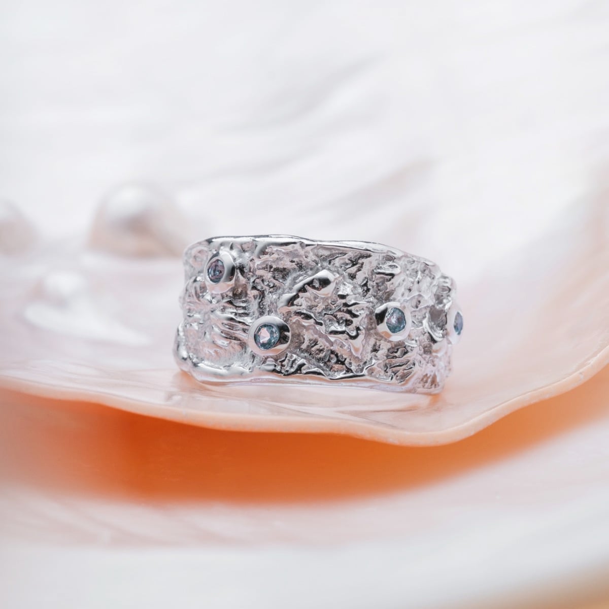 "Silverstream Ring": A textured silver ring set with topaz stones, exuding natural elegance.