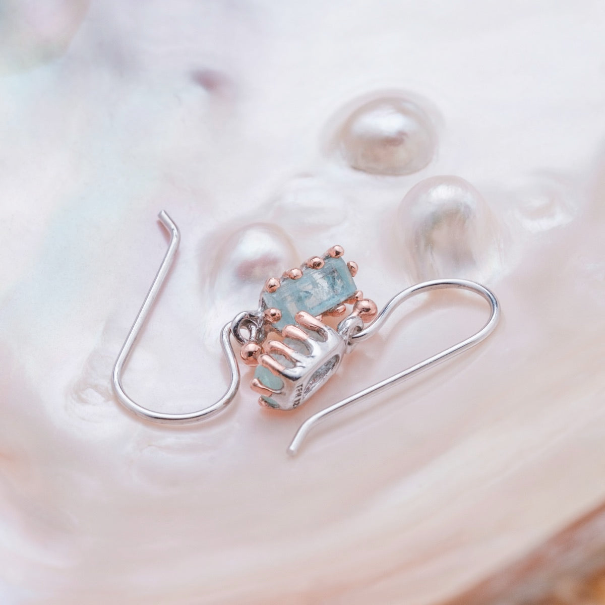 "Silverstream Earrings: Elegant rosegold earrings with aquamarine accents, showcasing a sophisticated and delicate style."