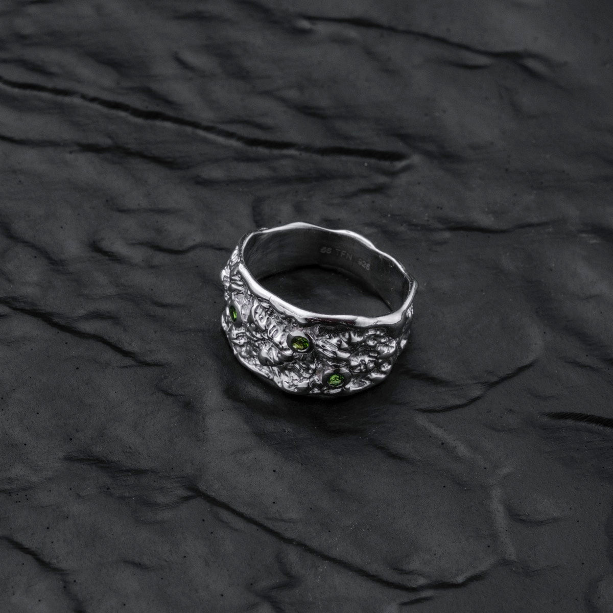 "Silverstream Ring" ring featuring a textured silver band with diopside stones, exuding an elegant and modern style.