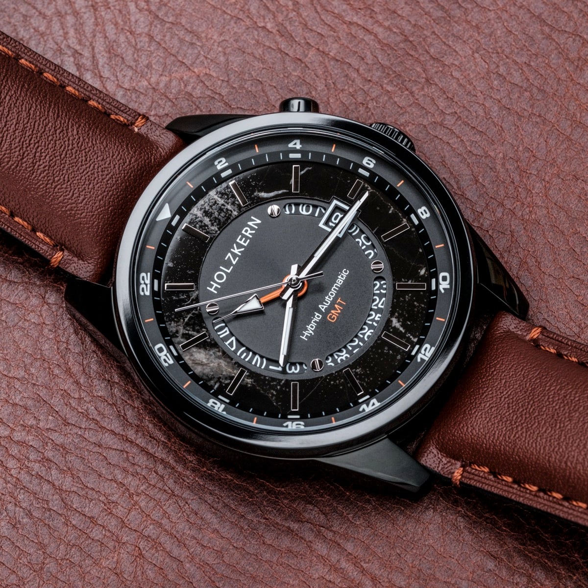 "Gmt Skywhirl" watch, featuring a marble and black design with a sleek, modern appearance on a brown leather strap.