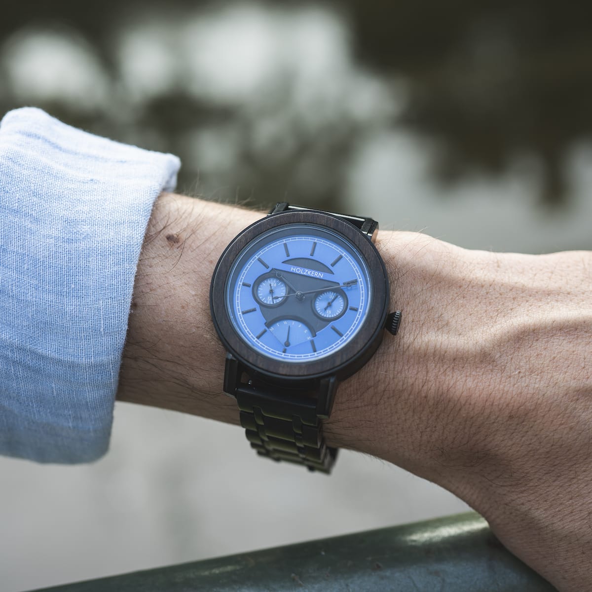 "Belize" watch featuring a blue dial and dark wood accents, worn on a wrist.