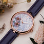 "Everbloom" watch featuring floral dial with plum blossom design and violet strap in elegant style.
