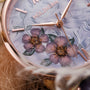 "Everbloom" watch with floral motif and elegant violet tones.
