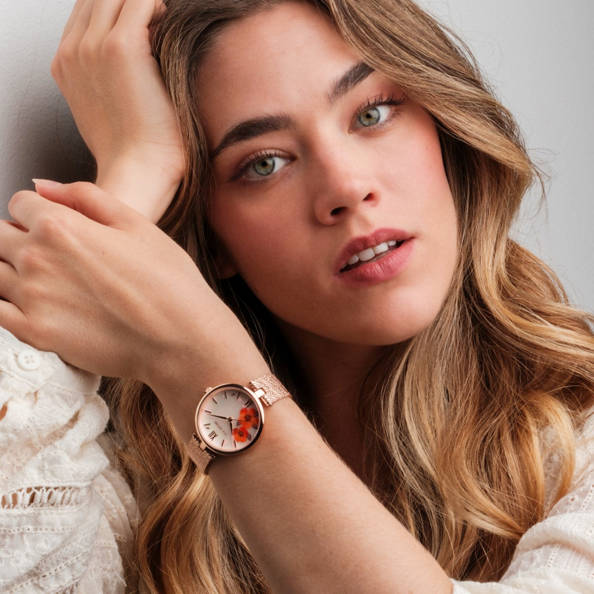 "Everbloom" watch in rose gold with a plum blossom dial design, worn on an elegant wrist.