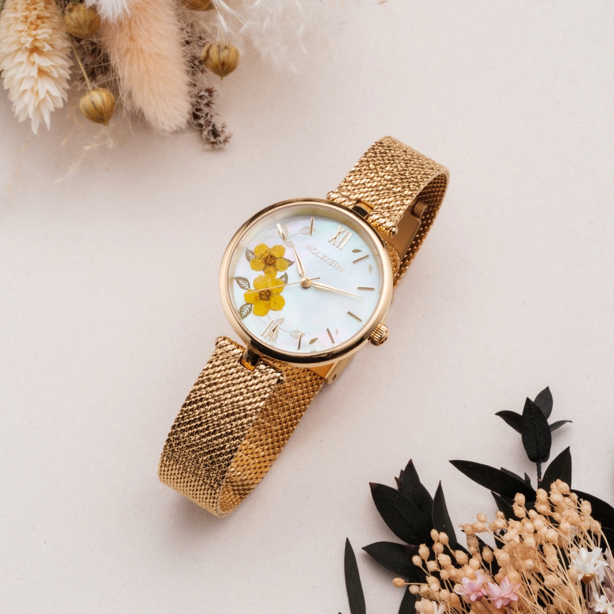 "Everbloom" watch with a gold mesh band and plum blossom design in a delicate floral style.