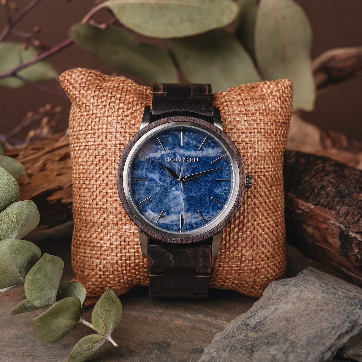 "Immanuel" watch featuring a striking blue sodalite face and rich maple accents, styled on a rustic burlap cushion.