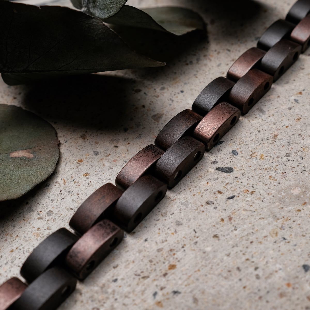 "Rondo" bracelet, featuring maple and antique copper links, showcases a rustic and elegant visual style.