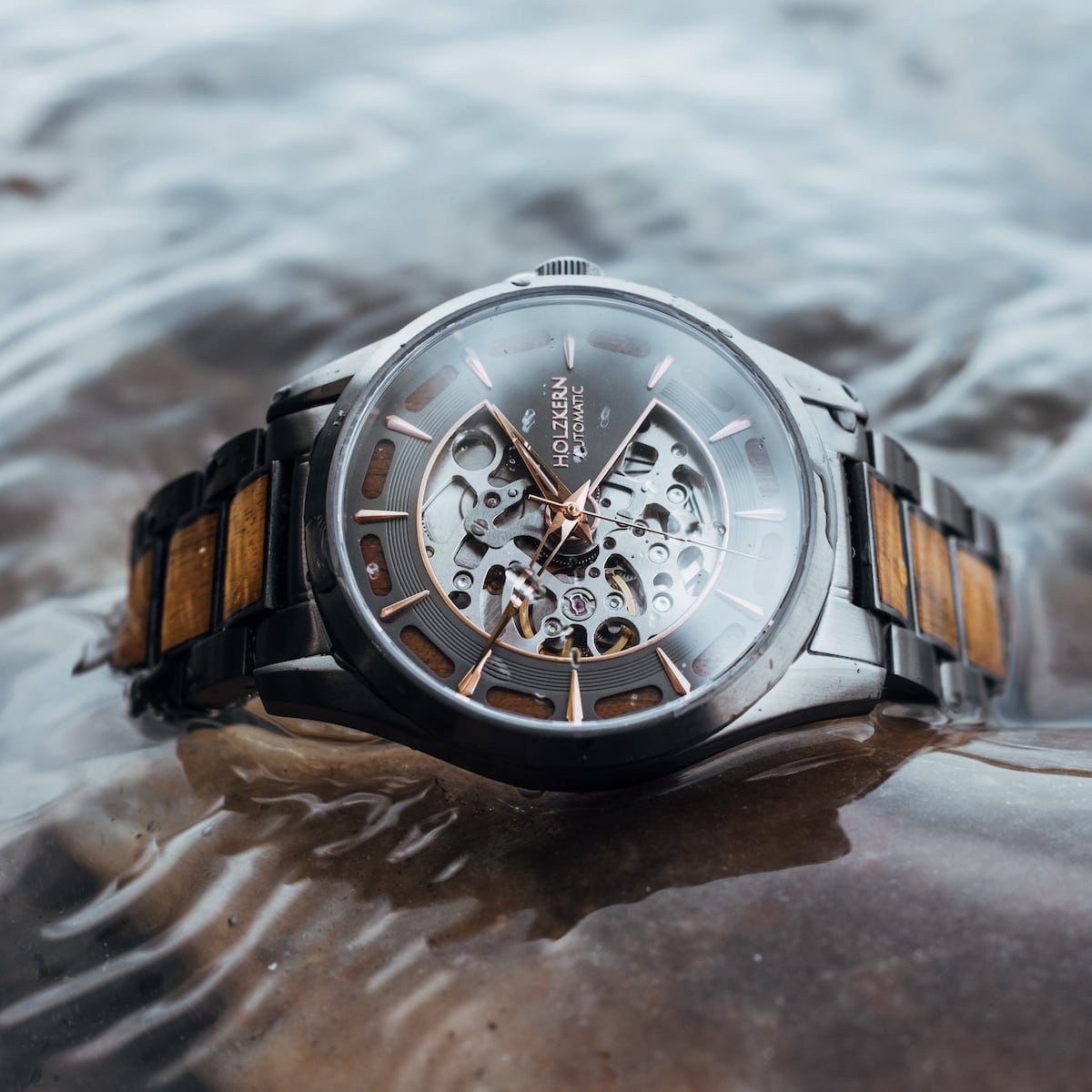 "Tenoumer" watch featuring a koa wood and dark gray design with a stylish skeletal dial.