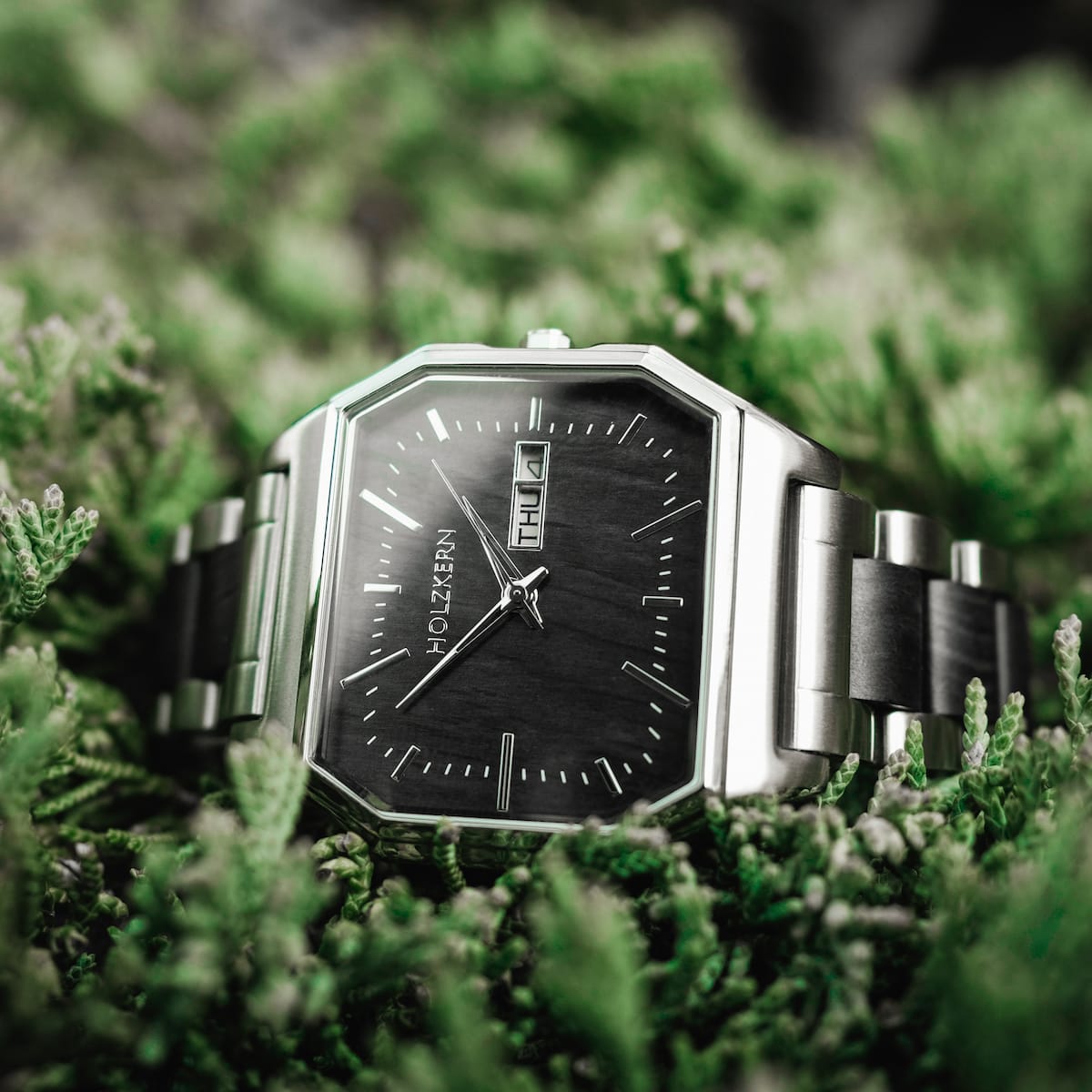 "Kéré" watch, featuring a sleek design with a maple finish, set against a vibrant natural backdrop.