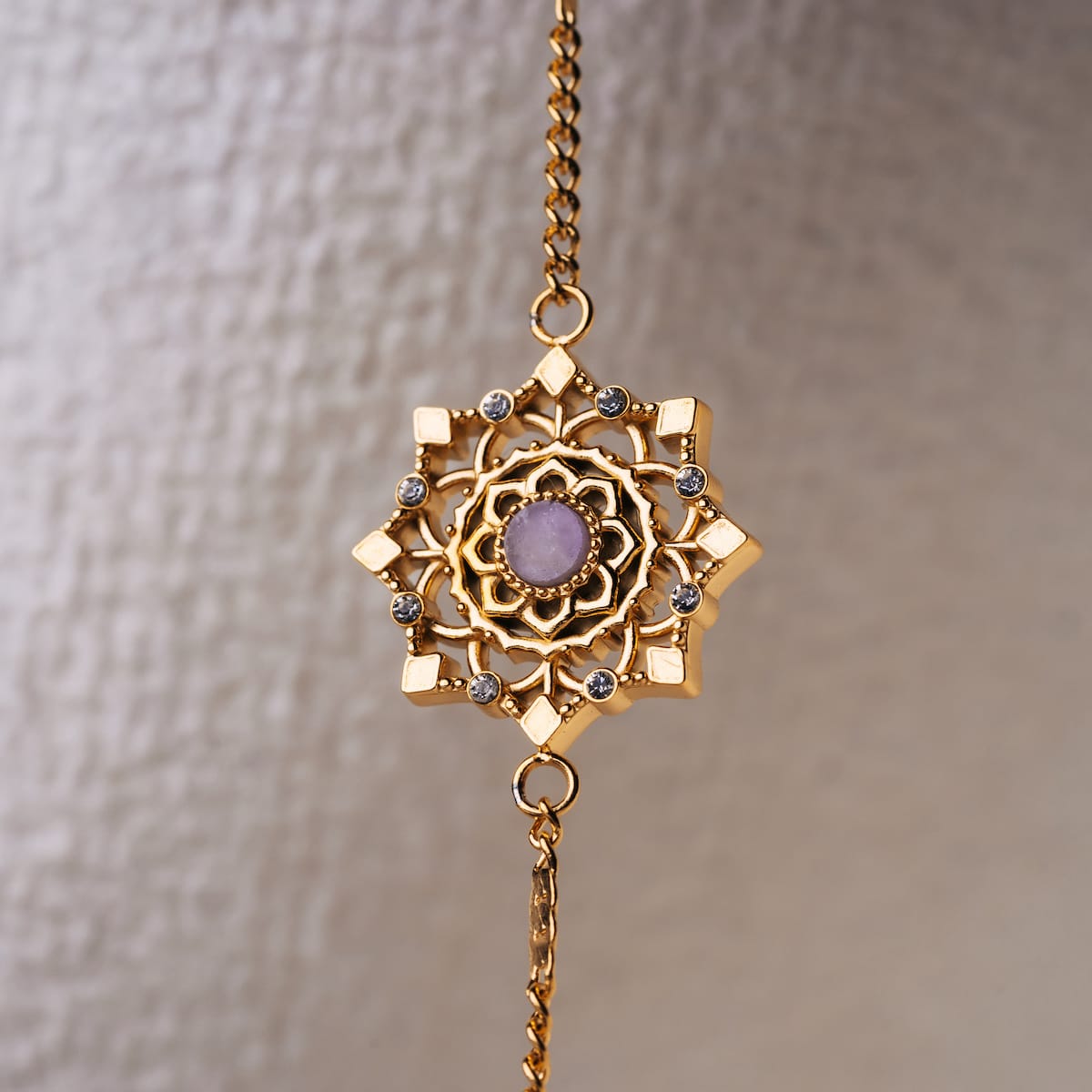 "Aphonia Bracelet" bracelet featuring an intricate gold design with amethyst accents.