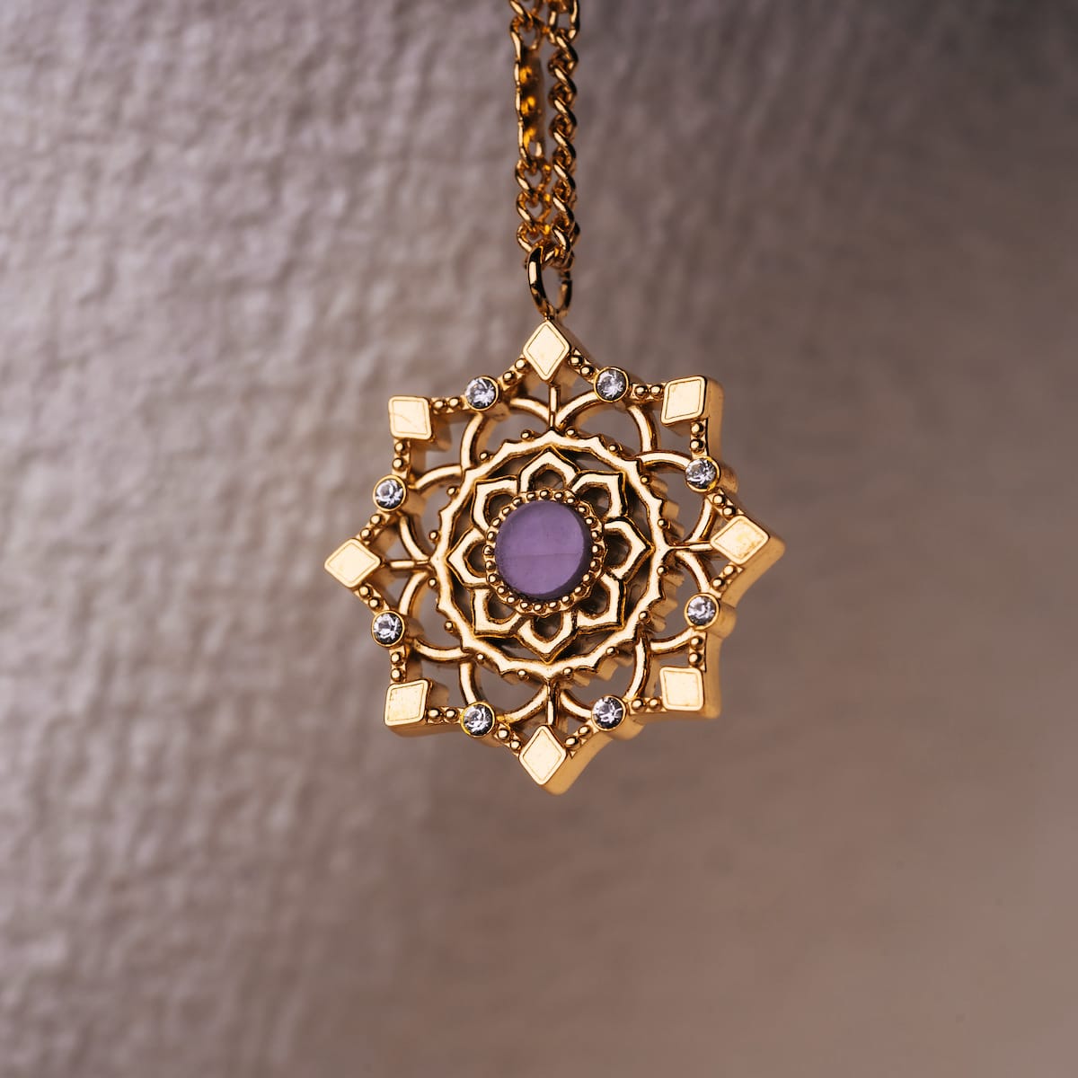 "Aphonia Necklace" necklace featuring an intricate gold design with an amethyst centerpiece.