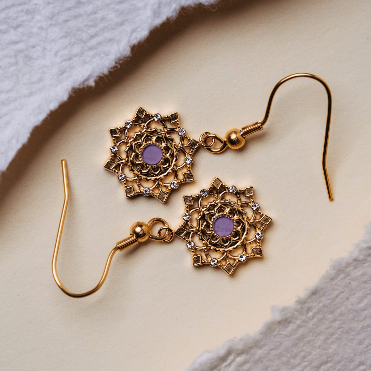 "Aphonia Earrings" earrings featuring intricate gold design with amethyst accents.