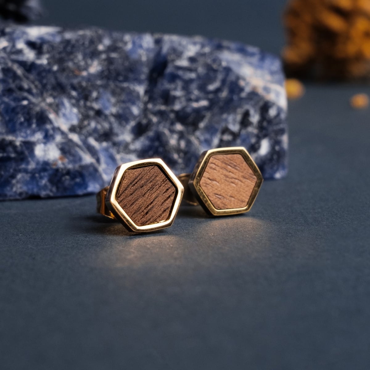 "Facade Earrings": hexagonal earrings featuring walnut and gold, showcasing a modern, textured style.