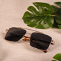 "The Talisman" sunglasses feature a sleek walnut and matte gold design with a modern aesthetic.