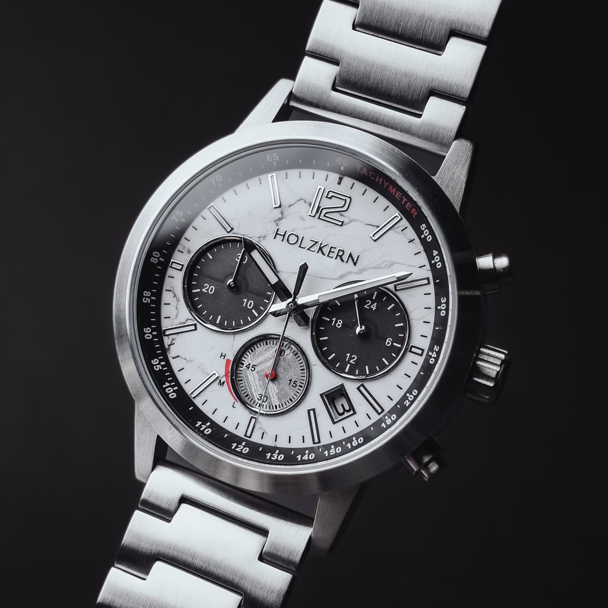 "Sagres", a men's watch, features a sleek marble and silver design with a sophisticated chronograph display.