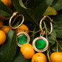 "Zendala Earrings" earrings, featuring a vibrant green nacre with a gold finish, surrounded by leaves and berries.