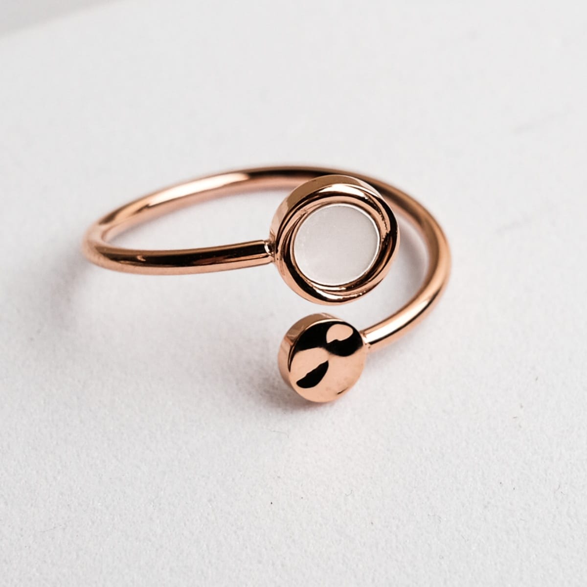 "Zendala Ring" ring featuring a rose gold finish and nacre accents, showcasing a sleek and modern design.