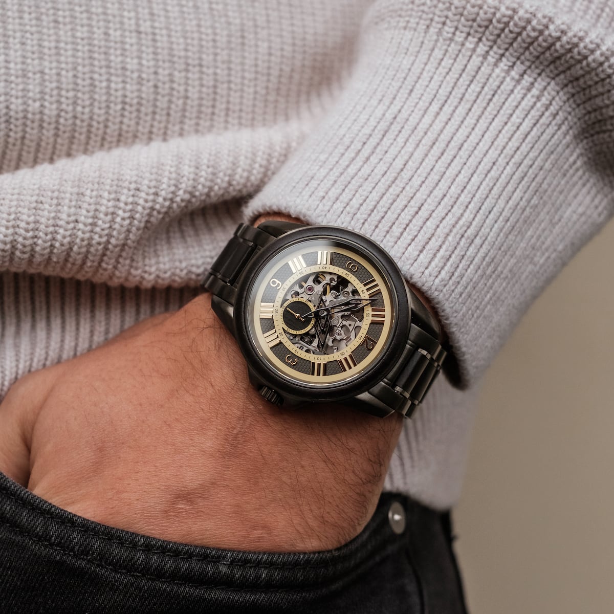 "Navona" watch featuring a sleek black design with a maple-accented skeleton dial, worn against a textured sweater.