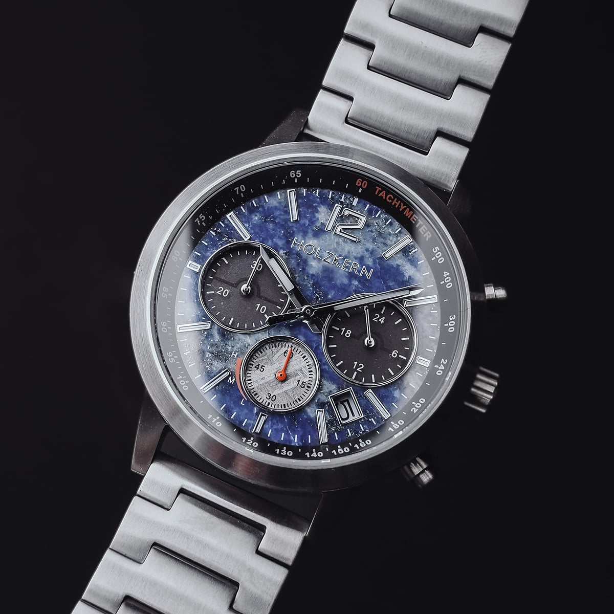 "Paracas", a sleek chronograph watch in lapis lazuli and silver with a bold, intricate dial design.