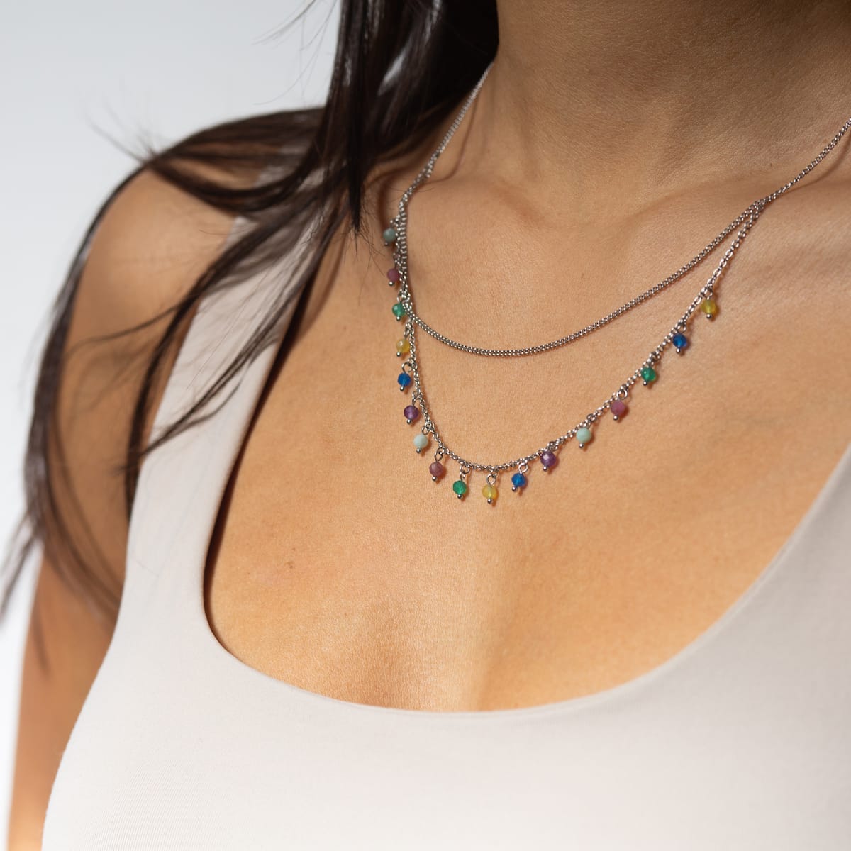 Free Play Necklace: Colorful beaded necklace in rainbow and silver tones, adding elegance and charm to any outfit.