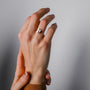 "Campania Ring", a stylish walnut and silver ring, elegantly worn on a hand.