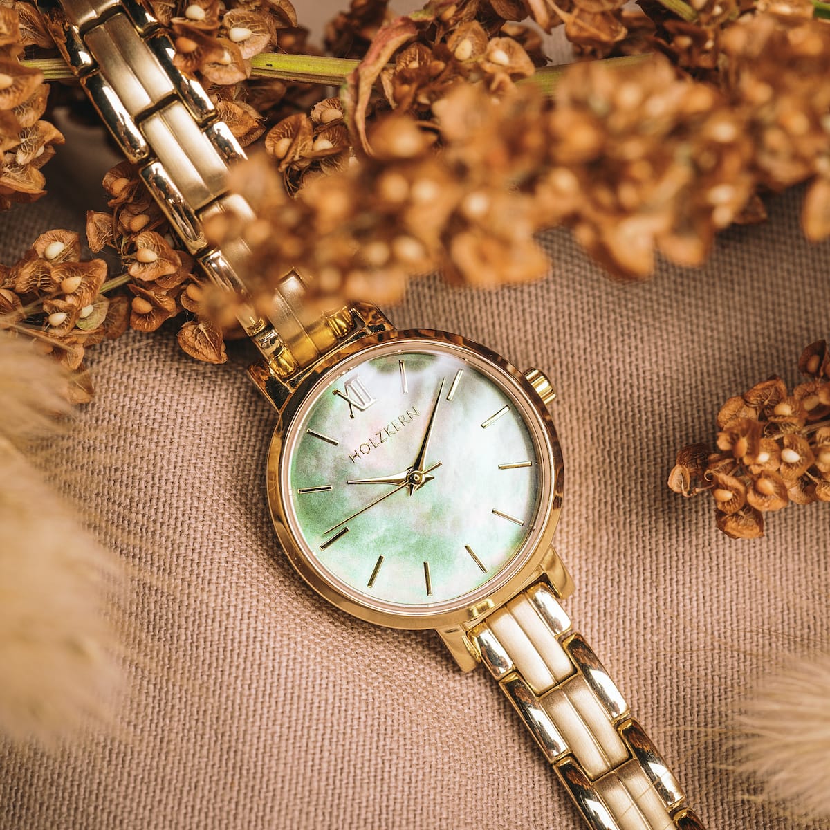 "Themis" watch with a nacre dial and gold bracelet, featuring an elegant and luxurious design.