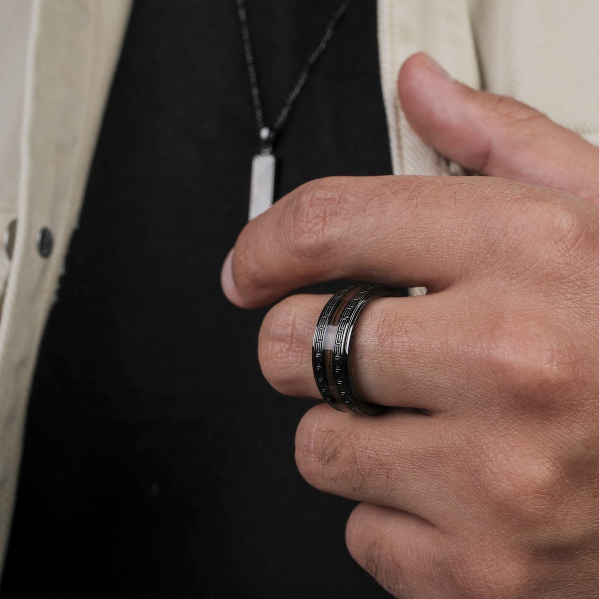 "Numerary Ring", a stylish ring, featuring walnut and gray tones worn on a hand.