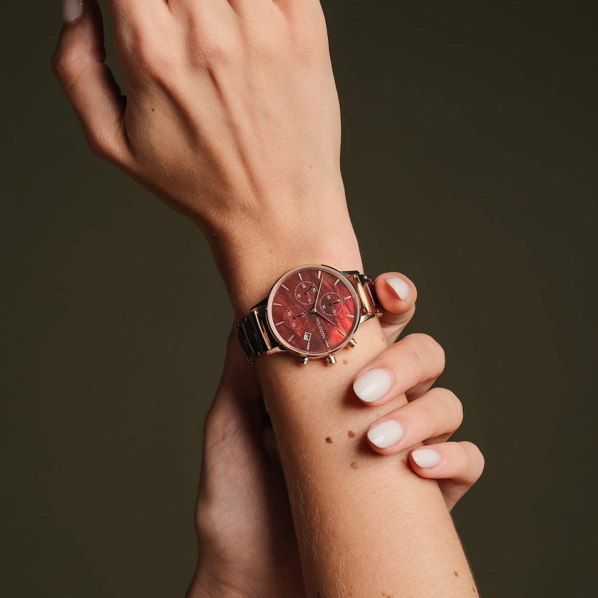 "Cheery" watch, featuring a red nacre face and ceramic accents, showcasing elegant and modern design aesthetics.
