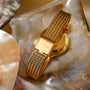 "Giggles" watch featuring a nacre and gold design with an elegant mesh band.