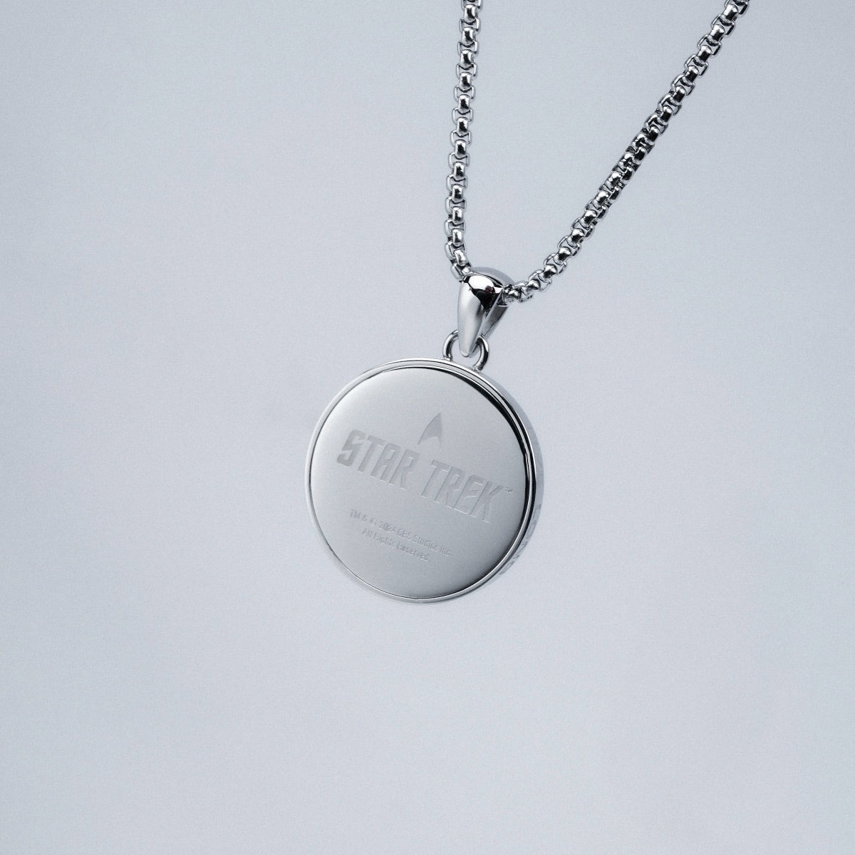 "Command Necklace", a sleek silver necklace featuring a round pendant with a sci-fi theme.
