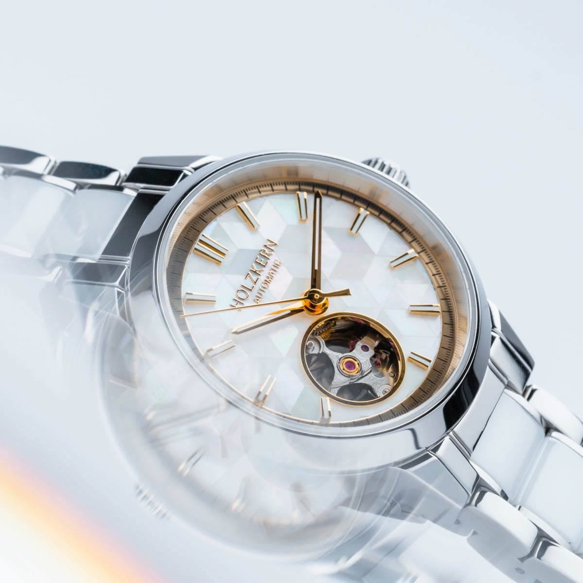 "Cristals" watch, featuring nacre and ceramic materials in a sleek, modern design with gold accents.